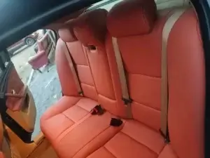 the interior of a car with red leather seats.