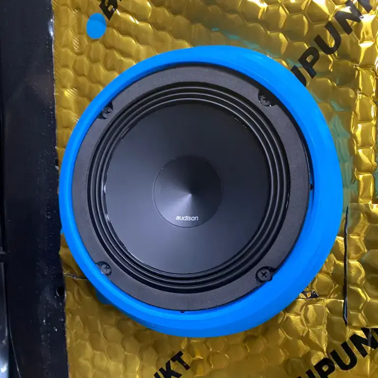 Blue speaker mounted on textured surface